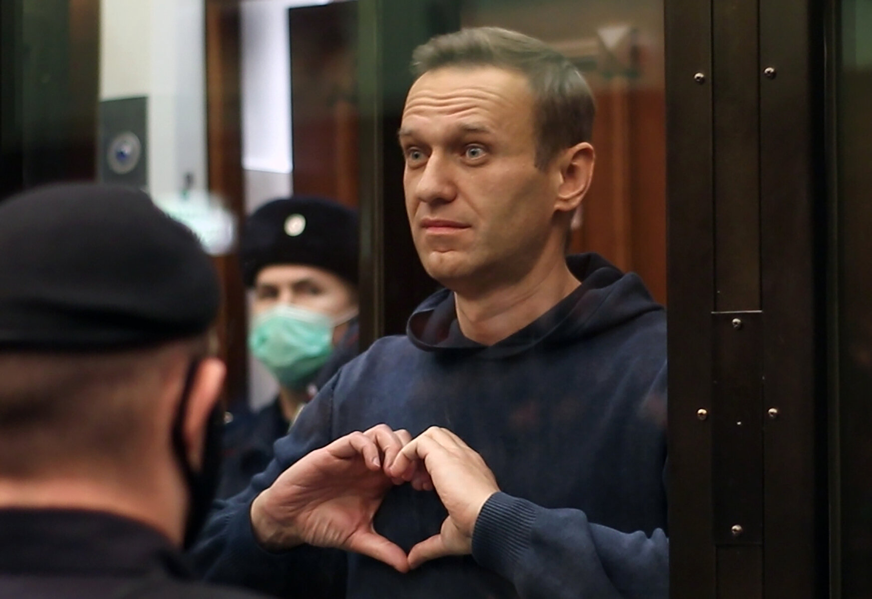 <p>Алексей Навальный показывает сердечко жене Юлии во время оглашения <a href="https://tvrain.ru/teleshow/vechernee_shou/prigovor-523880/" target="_blank">приговора</a> Мосгорсуда о замене условного срока в 3,5 года на реальный по делу &laquo;Ив Роше&raquo;, 2 февраля 2021 года.</p>
